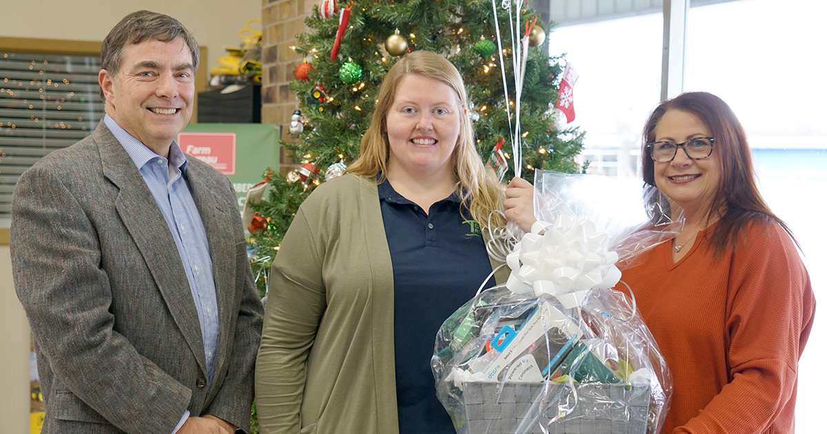 Gibson Connect man and woman flank the winning subscriber - a woman - to present her with a gift basket