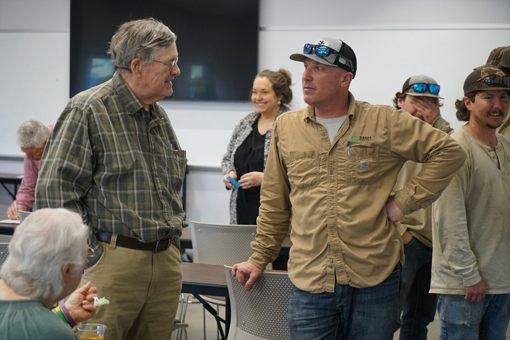 Jeff Boyd speaks with a lineworker at his retirement reception.