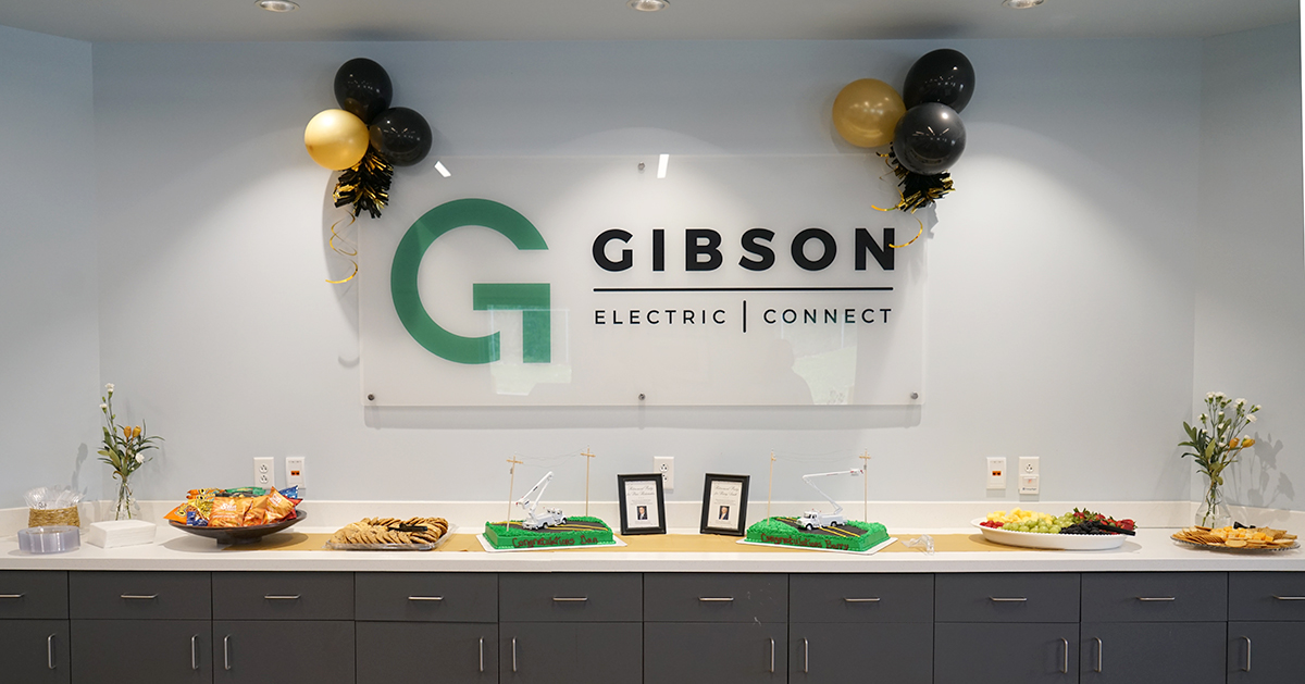 Gibson Electric and Connect sign displayed above a table with food, cakes and balloon decorations at a retirement reception.