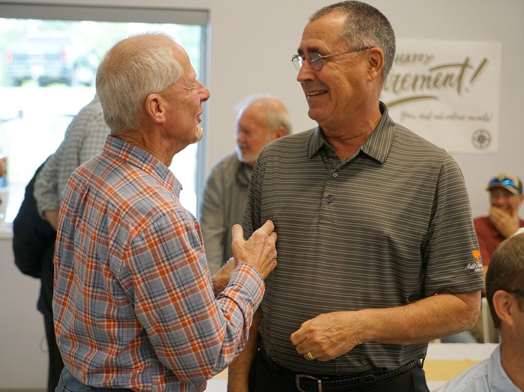 Dan Rodamaker smiles with a retired colleague.